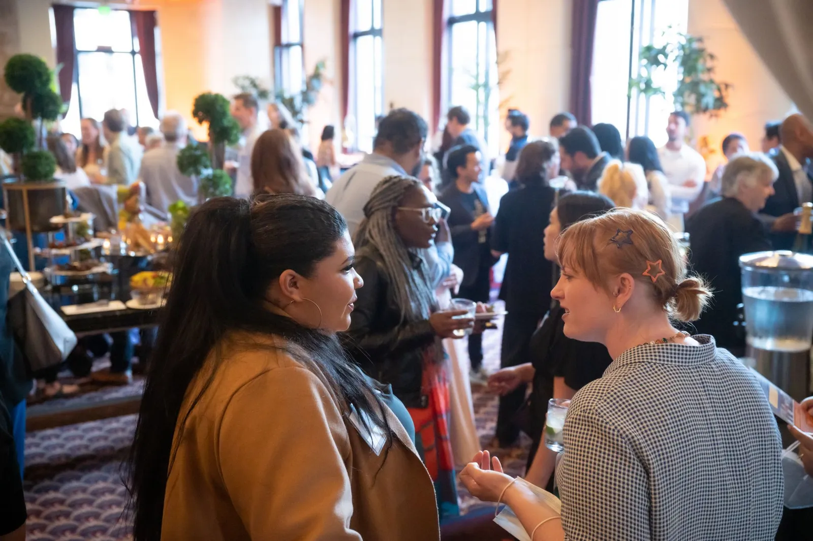 Two members talking at a crowded YIMBY Action reception