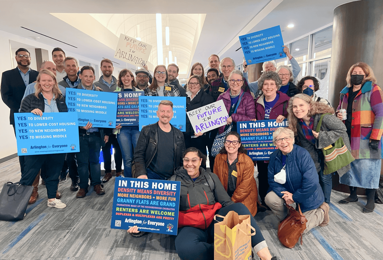 Arlington for Everyone members holding Yes to missing middle signs before a county hearing