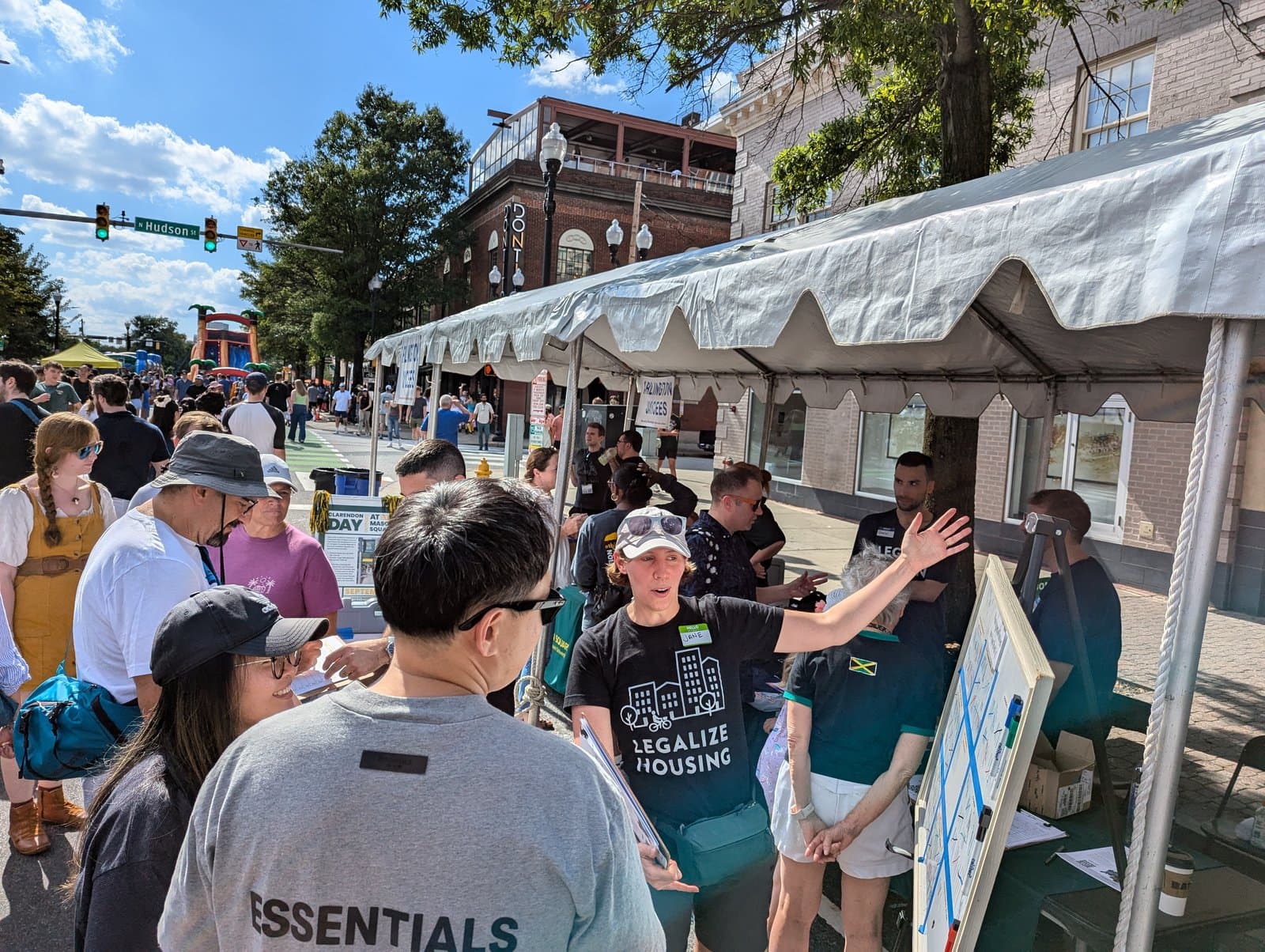 A Legalize Housing volunteer talking with passersby at the YIMBYs of Northern Virginia tent at Clarendon Day