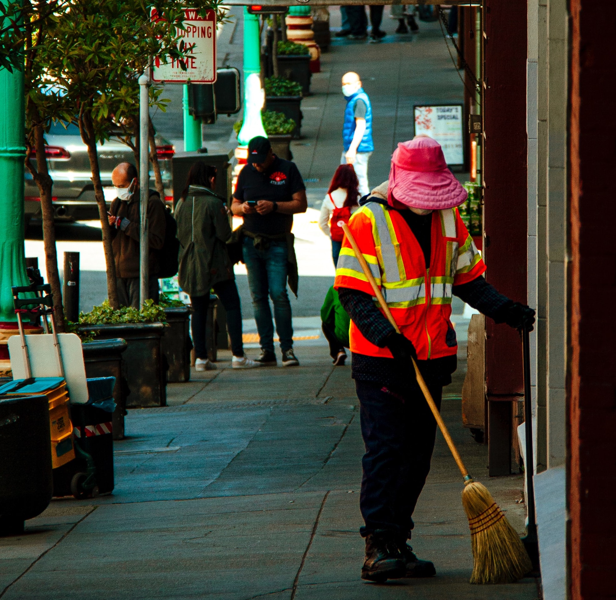 person sweeping sidewalk in san francisco